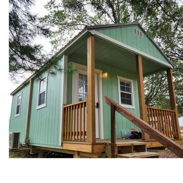 Cozy mint green tiny house with wooden porch and steps.