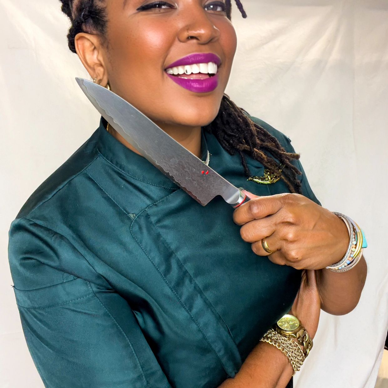 Smiling chef holding a knife confidently.