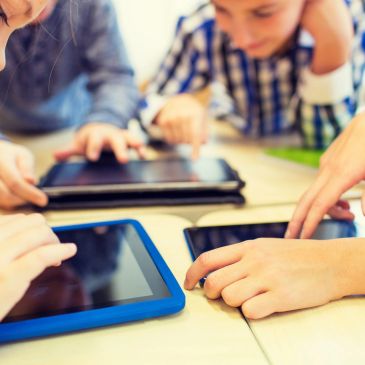 Children using tablets in a classroom.
