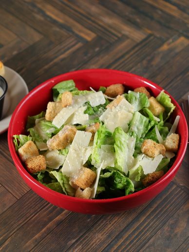 A fresh Caesar salad made with crisp romaine lettuce, shaved Parmesan cheese, crunchy garlic crouton