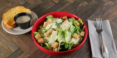 Classic Caesar salad with crisp romaine lettuce, shaved parmesan cheese, garlic croutons, and Caesar