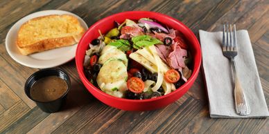 Dominic Antipasto Salad with salami, provolone cheese, tomatoes, cucumbers, red onion, black olives,