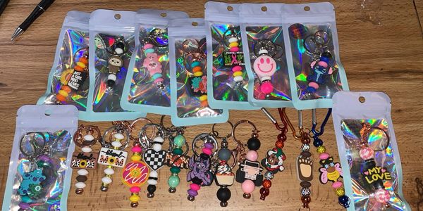 Collection of colorful keychains and charms displayed on a wooden surface.