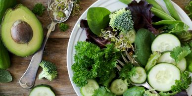 Fresh green salad with avocado and cucumber slices.