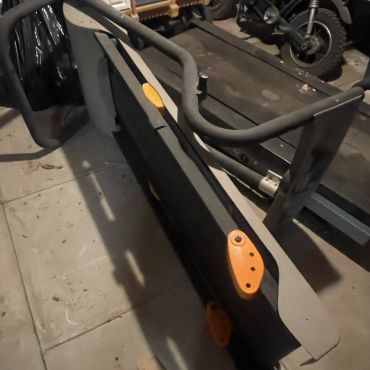 Folded treadmill stored indoors.