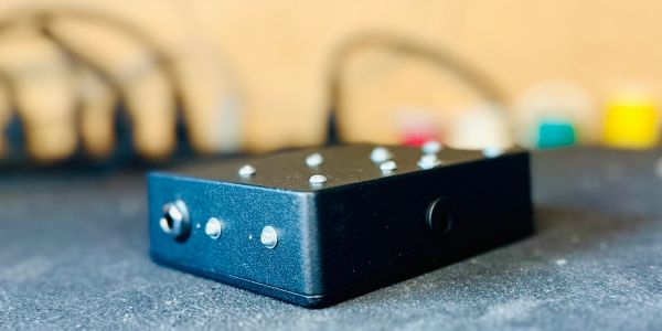 Close-up of a black electronic device with buttons on a textured surface.