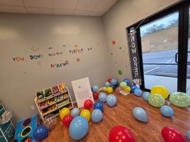 Colorful balloons and a motivational wall message in a small room.