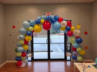 Colorful balloon arch at a doorway.