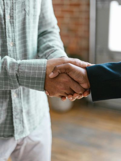 Two people shaking hands in a casual indoor setting.