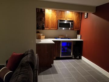 kitchenette with lights on near brown sofa