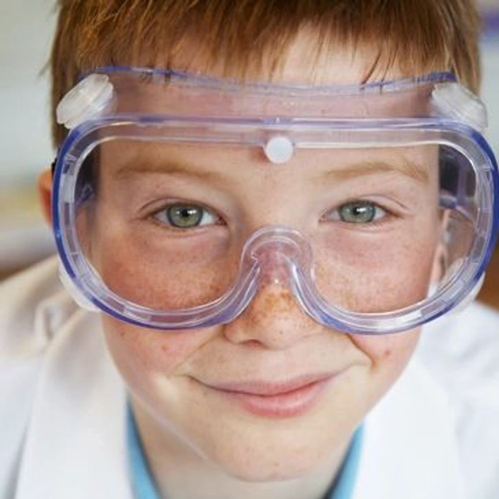 A boy smiling looking ahead and wearing an Eyeglass