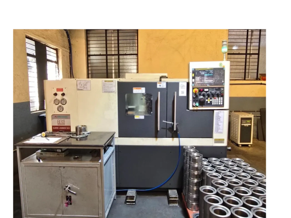 Industrial CNC machine with metal components in a workshop.