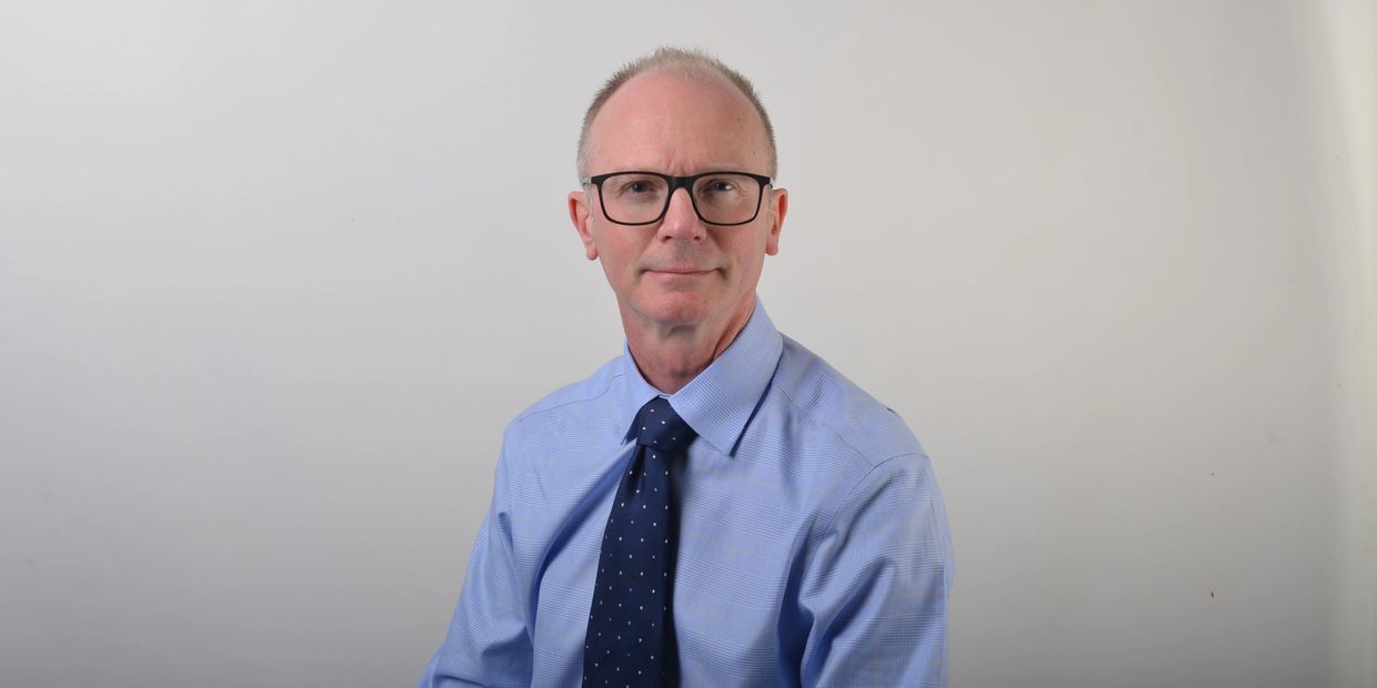 Doctor Jonathan Pollock wearing a blue shirt 