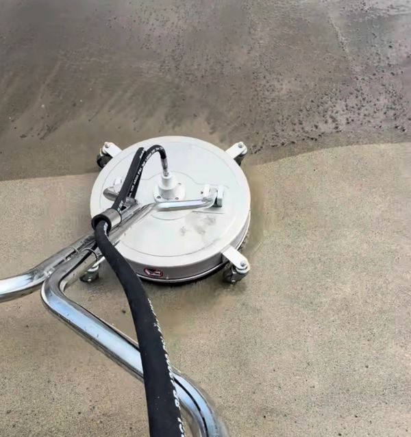 A surface cleaner cleaning a concrete floor, showing a clear difference between cleaned and uncleaned areas.