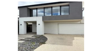 Modern two-story house with large windows and a clean driveway.