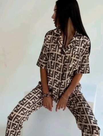 Woman wearing a stylish matching patterned outfit, sitting with legs apart.