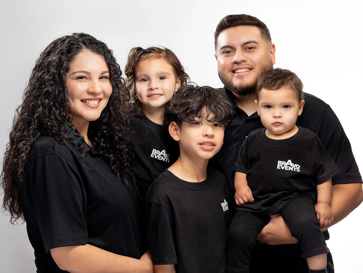 Happy family of five wearing matching black shirts with 'Bravo Events' logo.