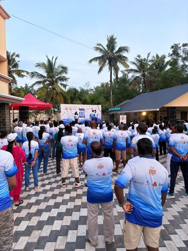 Group event with people wearing matching shirts outdoors.