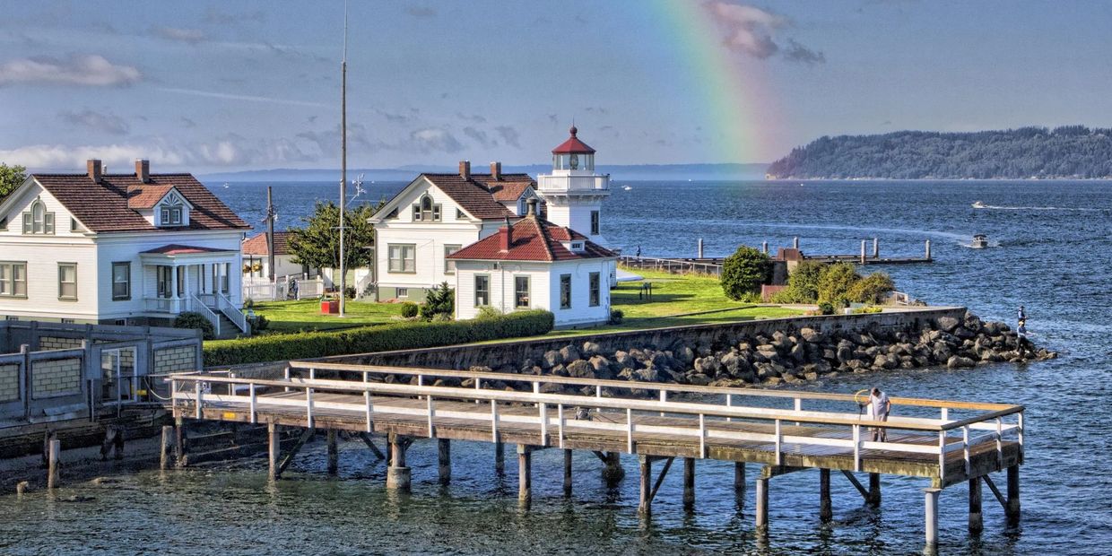 dock next to the ocean with a rainbow in the background