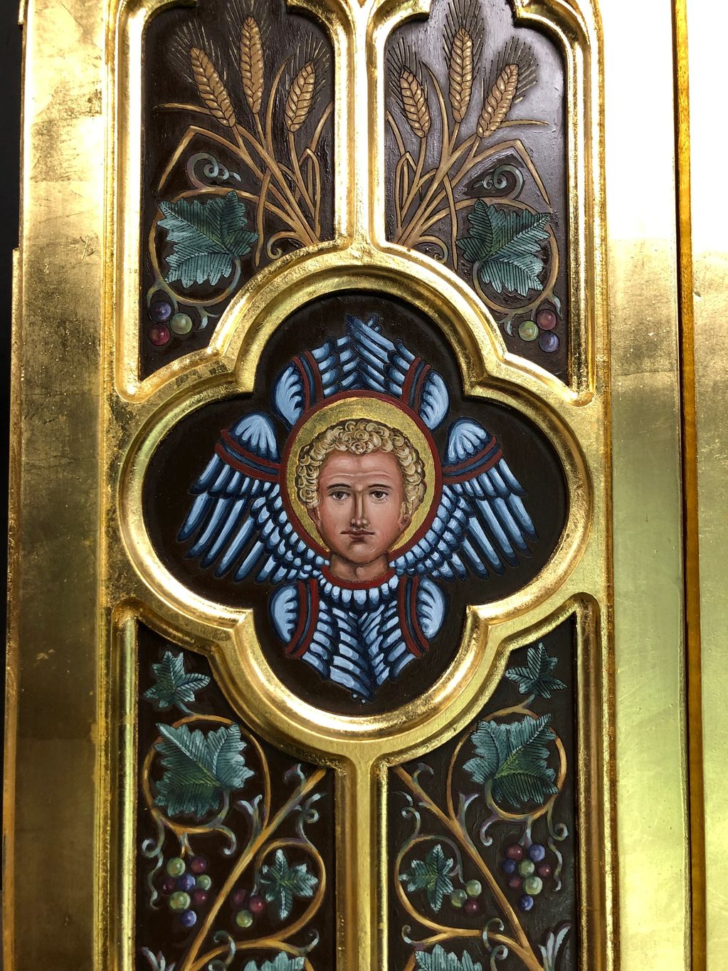 Decorative religious panel with angel and golden frame.
