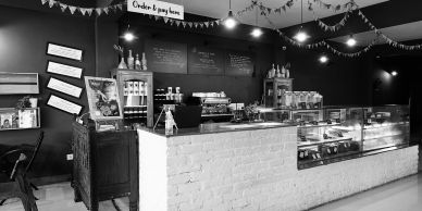 Cozy cafe counter with pastries and menu on blackboard.