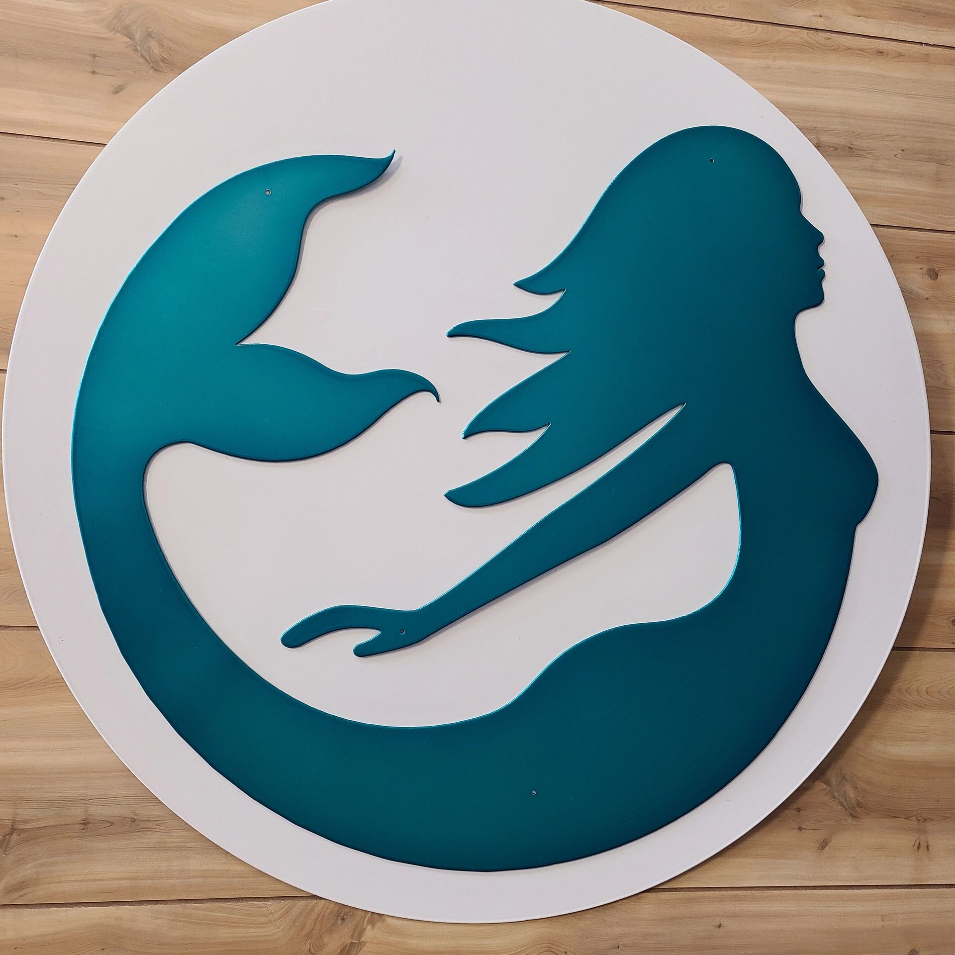 Custom metal company sign featuring a mermaid logo. Custom metal by the Koi Lagoon