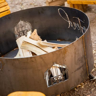 A round, wood-burning fire pit fabricated by the custom metal fabricators at the Koi Lagoon