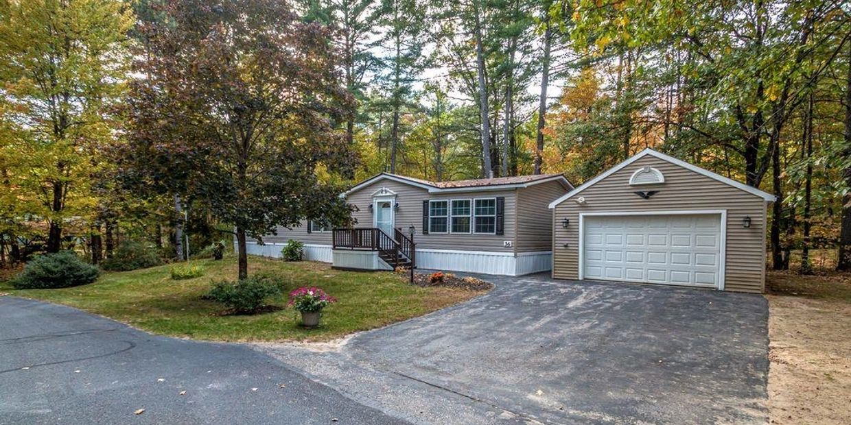 A single-story house with an attached garage surrounded by trees.