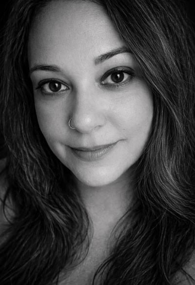 Black and white close-up portrait of a woman with long hair and a nose ring.