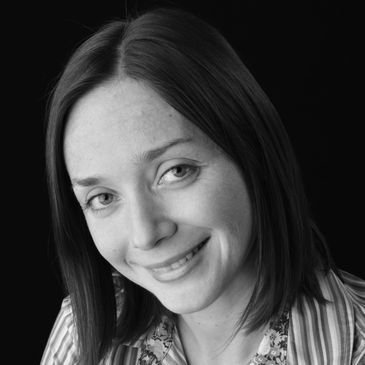Smiling woman with straight hair in a striped shirt.