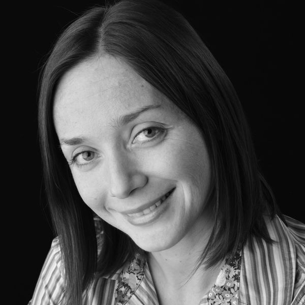 Smiling woman with straight hair in a striped shirt.