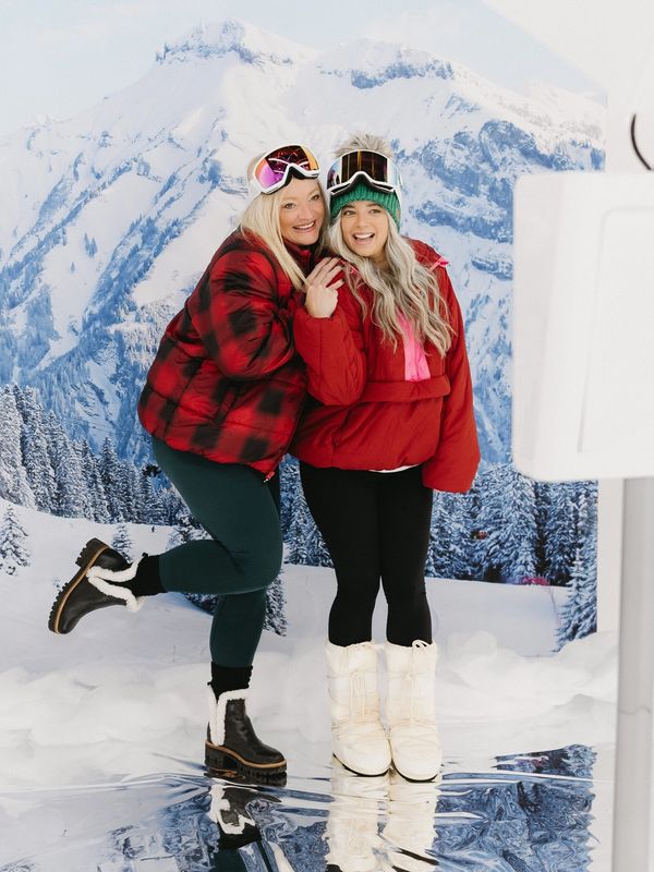 photolounge.ca Guest posing at a sleek, open-air digital photo booth with a après-ski backdrop.