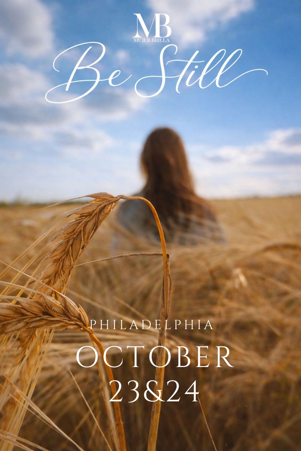 Close-up of wheat in a field with a person blurred in the background.