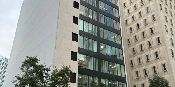 Modern office buildings with trees in the foreground.