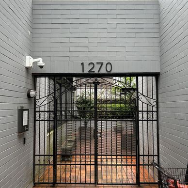 Black iron gate at a house entrance with the number 1270.