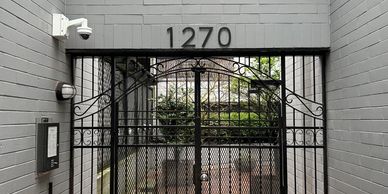 A gated entrance with a house number and CCTV camera.