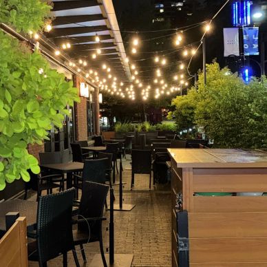 Outdoor dining area with string lights at night.