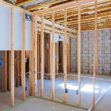 Interior view of a house under construction with wooden framing.