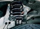 Close-up of a car suspension spring and tire.