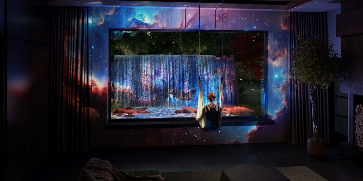 Person on swing facing a glowing waterfall with cosmic wall projections.
