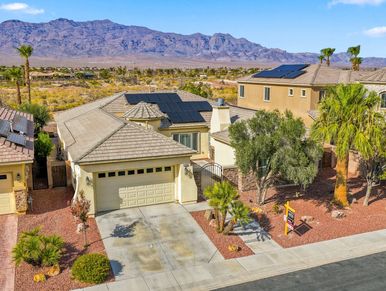 House with solar panels in a desert neighborhood.