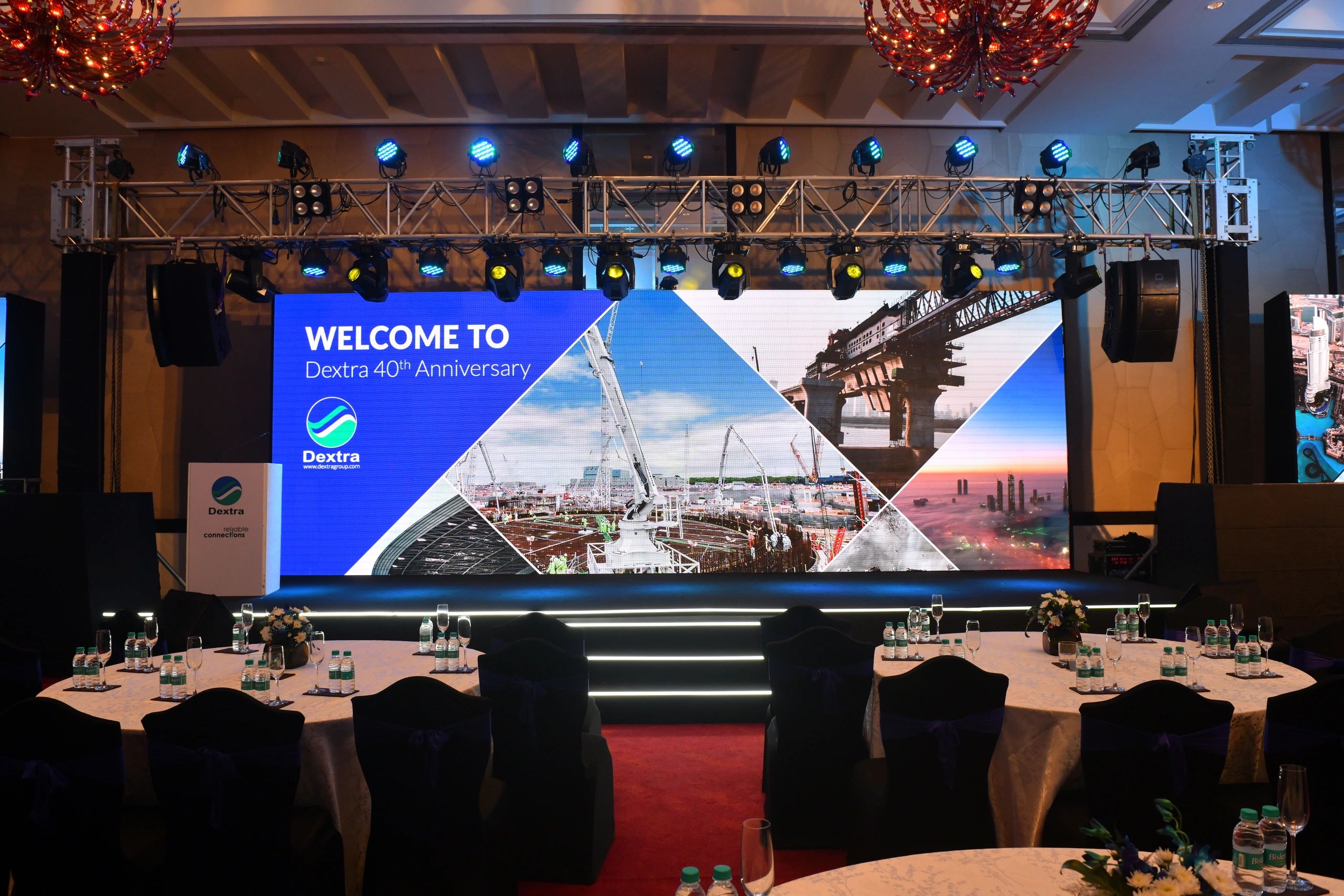 Event stage welcoming guests to Dextra's 40th Anniversary celebration. Corporate event stage production with LED screen, professional lighting and elegant event décor by The Creative Concept in Mumbai.