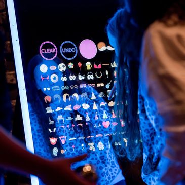 Person interacting with a touchscreen displaying various colorful icons and options.