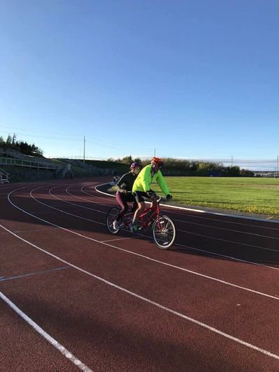 People riding  a tandem bike 