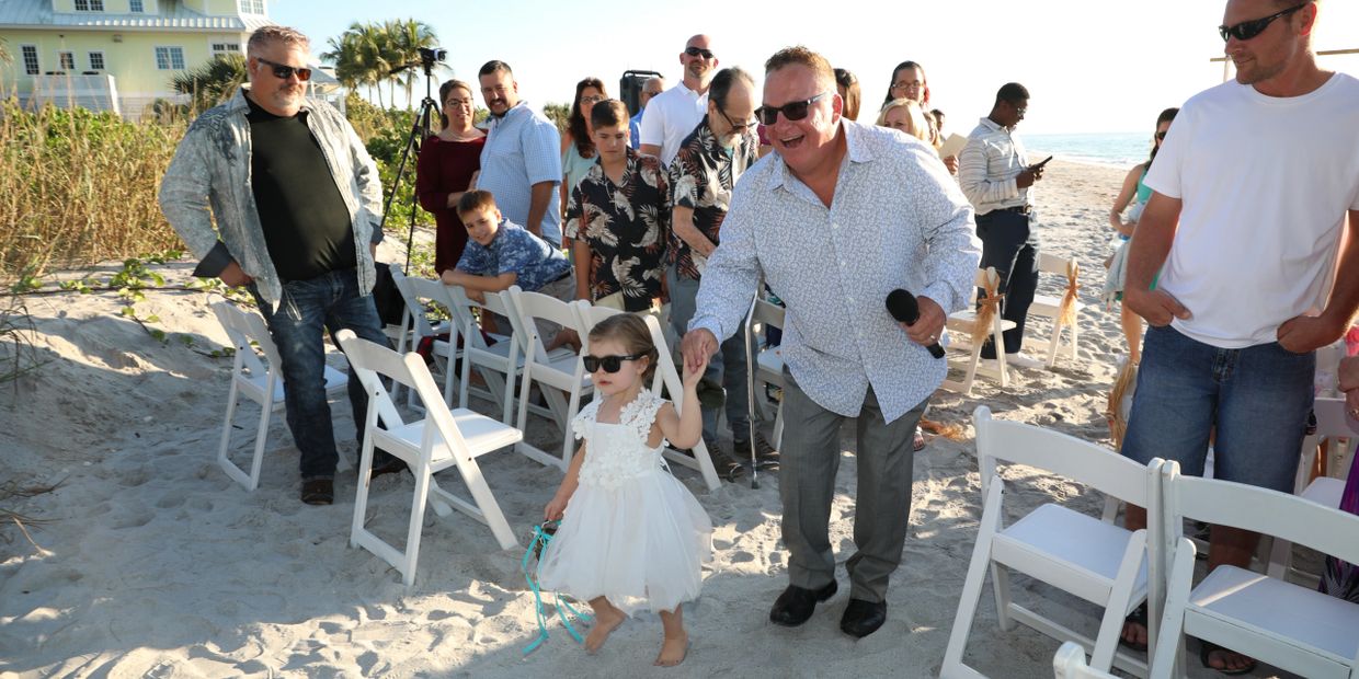 Wedding officiant Allan Z of Beach Breeze Weddings, being lead by the flower girl in recessional!