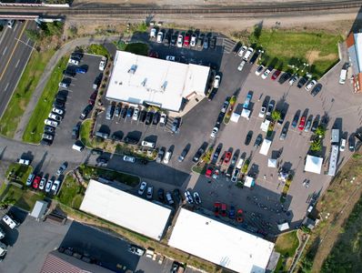 Aerial view of a busy parking lot with cars and buildings.