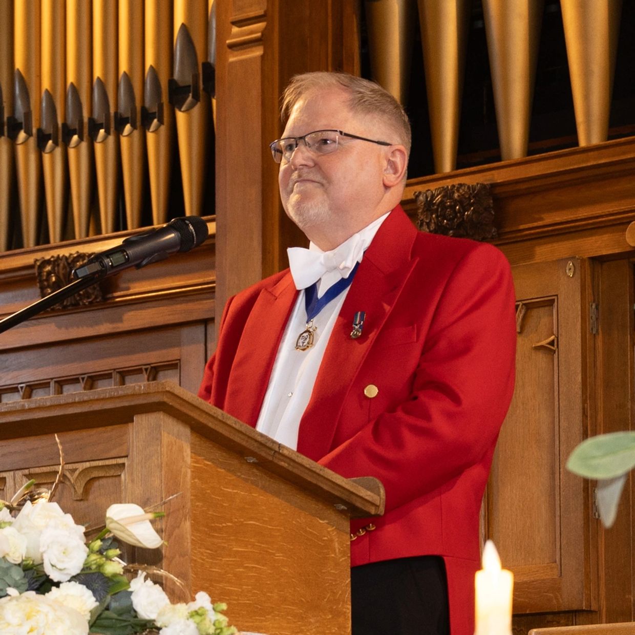 'Ian the Toastmaster' as a Cheshire Toastmaster in a red jacket