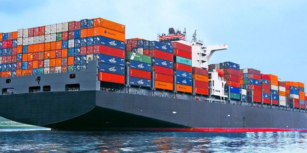 A large cargo ship loaded with colorful shipping containers at sea.