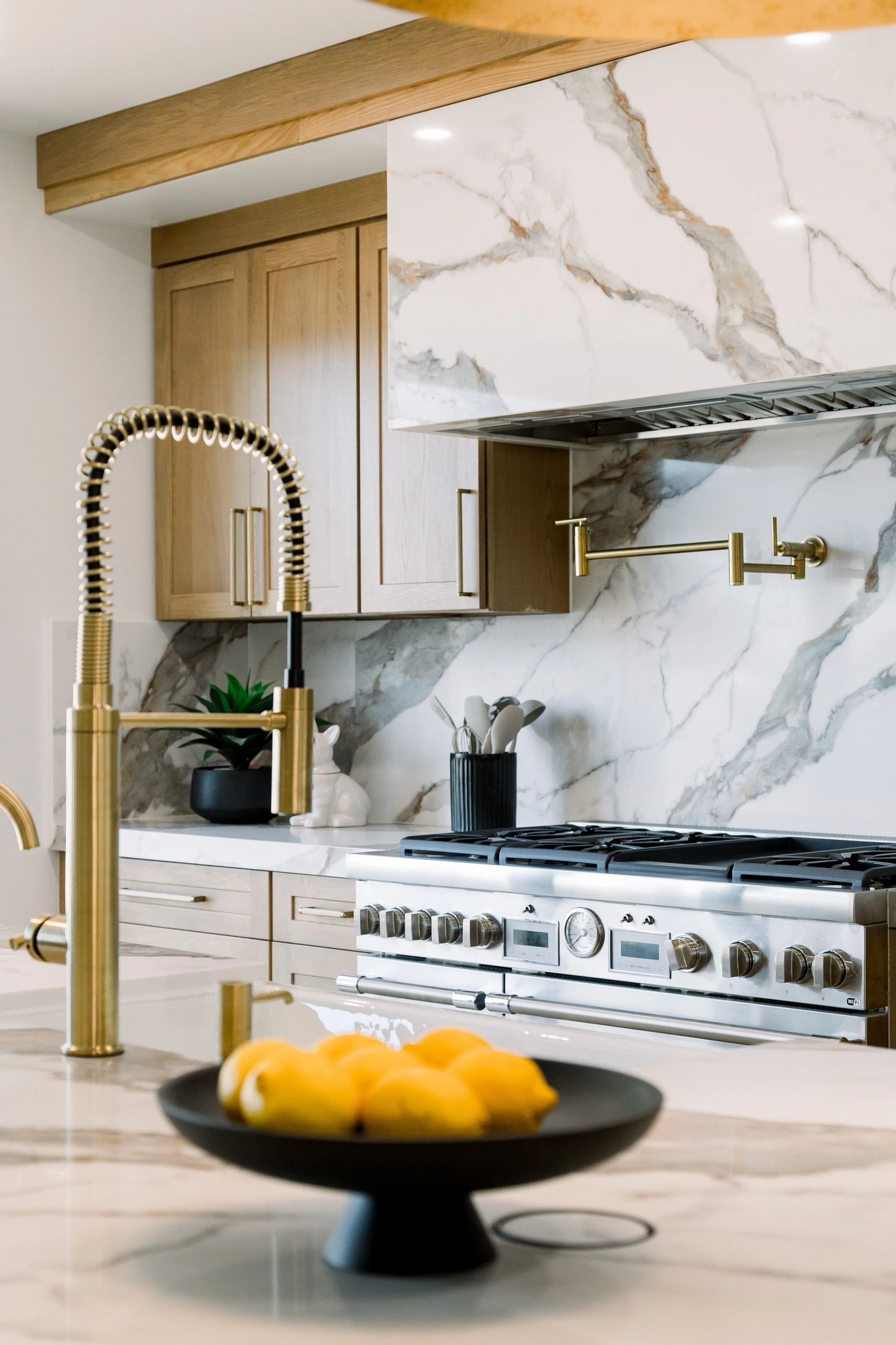 Side view of kitchen stove with gold sink head in front view. 