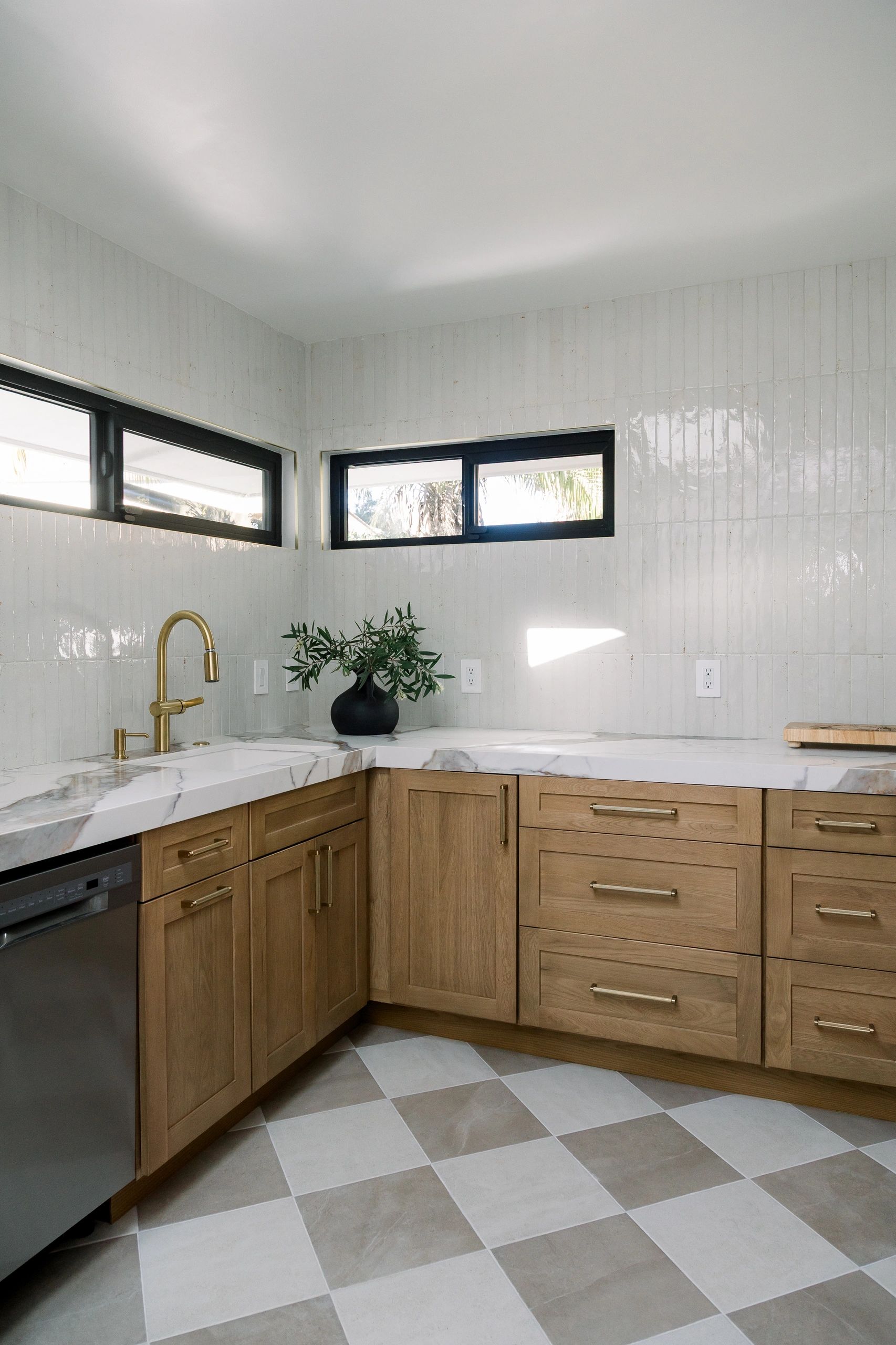 Pantry. Wooden cabinets with golden hardware, light checkered flooring and white countertop